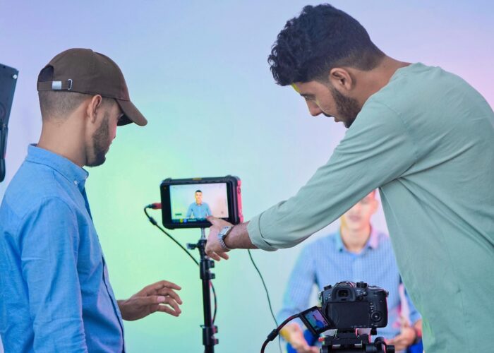 Video production crew filming a presenter in a studio